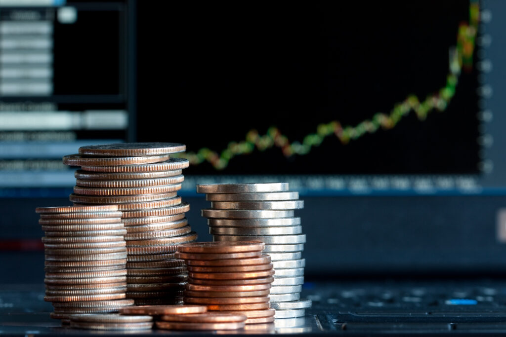 Stacks of coins  and a up trend chart as the background