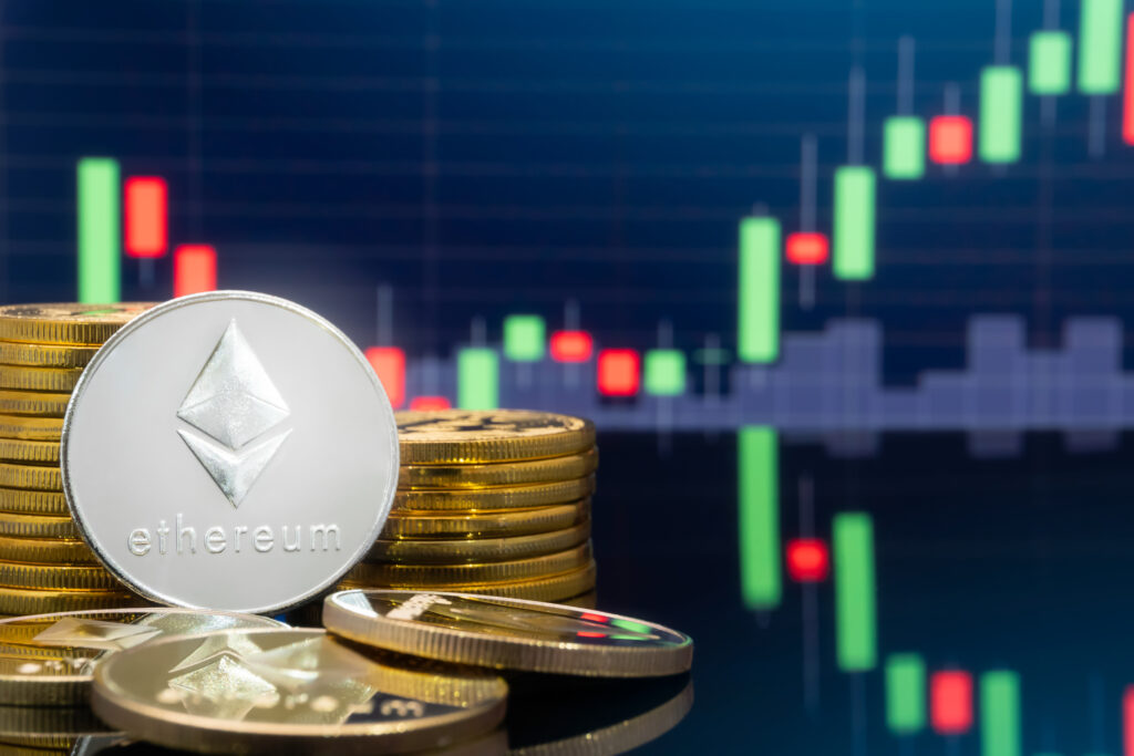 Ethereum (ETH) and cryptocurrency investing concept - Physical metal ethereum coins with global trading exchange market price chart in the background.